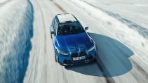 BMW M3 Touring rijdend voorkant van boven in de sneeuw