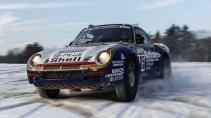 Porsche 959 Parijs-Dakar rijdend in de sneeuw schuin voor