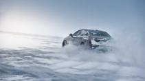 BMW i5 testauto driftend op een bevroren meer schuin achter