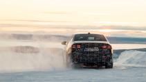 BMW i5 testauto driftend op een bevroren meer schuin achter