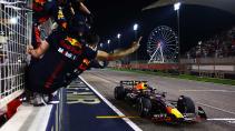 GP van Bahrein 2023 Verstappen gaat over de finish gezien vanaf de pitmuur met Red Bull personeel