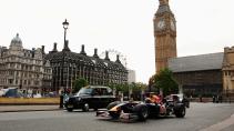Red Bull F1-auto rijdend naast een Londense zwarte taxi voor de Big Ben