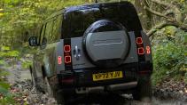 Land Rover Defender 130 rijdend schuin achter modder