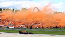 GP van Oostenrijk 2022 Sprint race Verstappen rijdend voor de oranjetribune met oranje rook