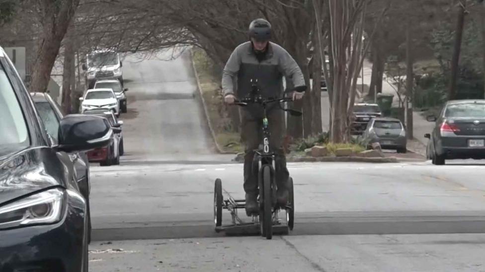 Deze fietser gaat de straat op om lekke banden van auto’s te voorkomen